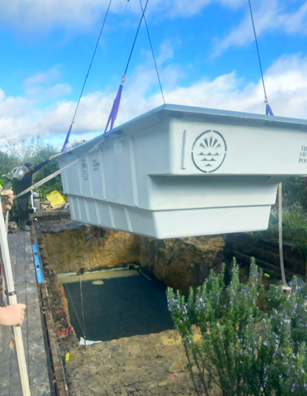 Fibreglass pool shell being lowered into place